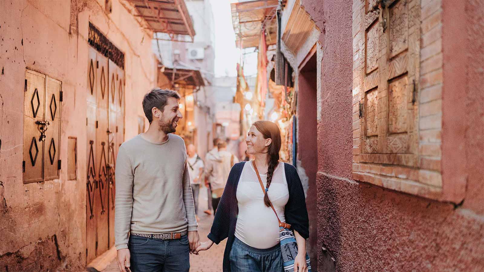 A couple walking hand in hand through the traditional narrow streets of Marrakech’s Medina.