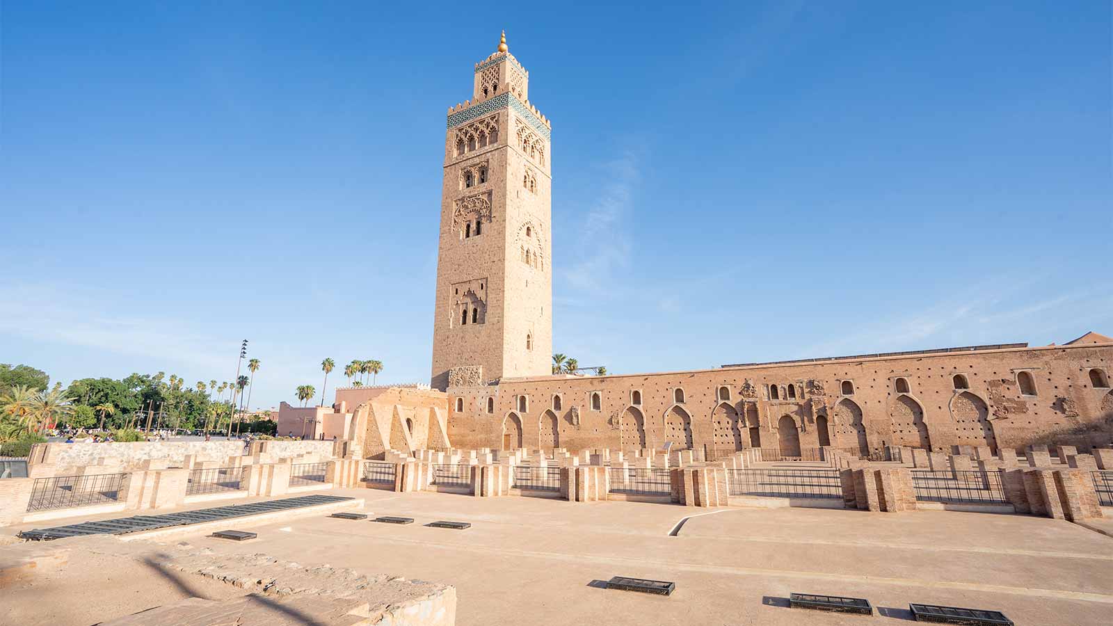 Panoramic view of the Koutoubia Mosque and its surrounding gardens under clear blue skies.