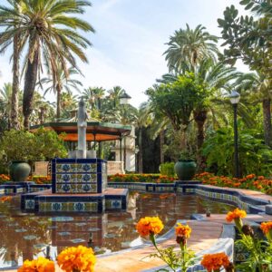 Majorelle Garden with palm trees, bright flowers, and the iconic fountain in Marrakech.