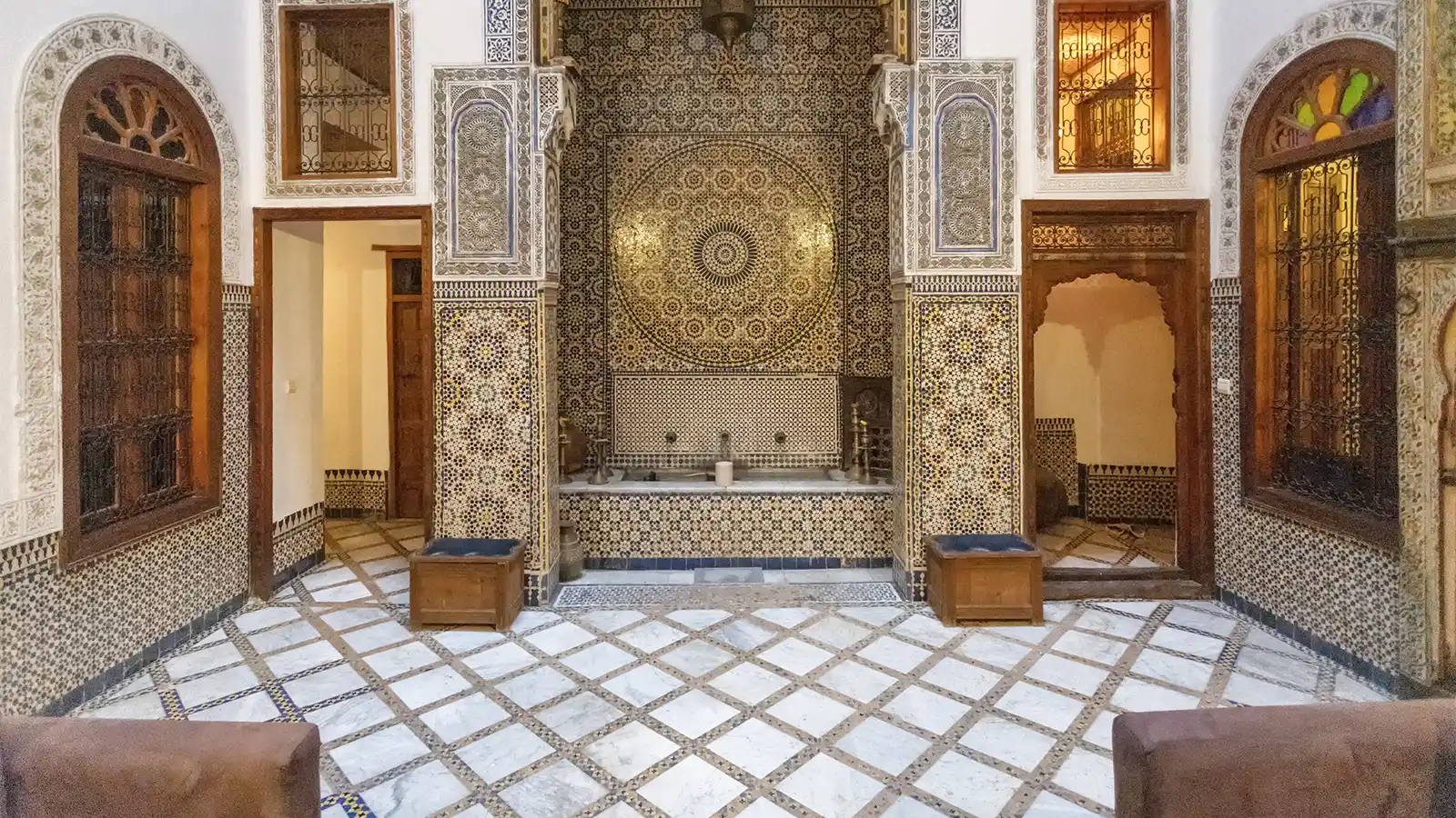 Fes medina guided tour inside a traditional riad courtyard with Moroccan zellige and architecture