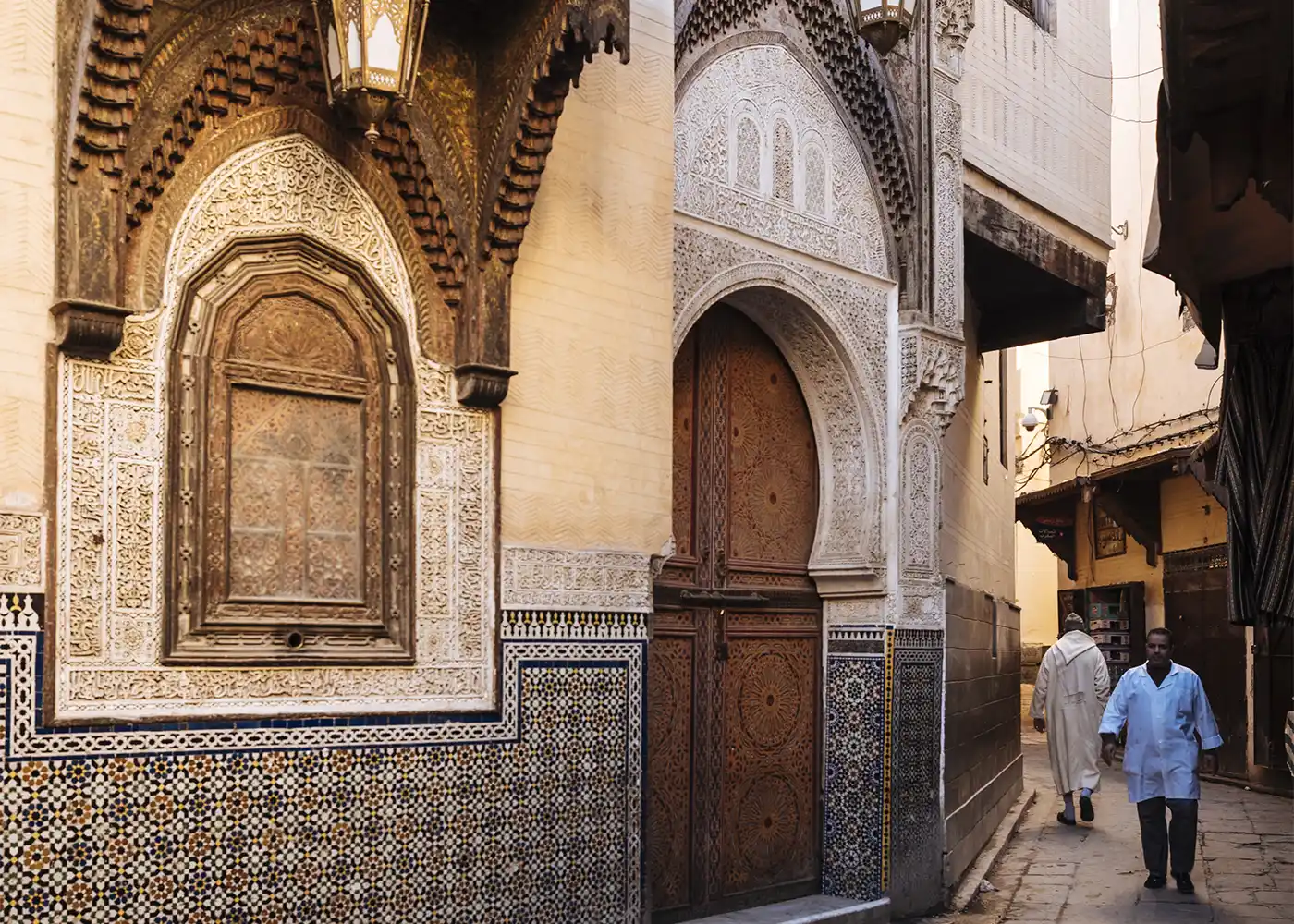 Traditional carved doorway and zellige tiles in the medina of Fes